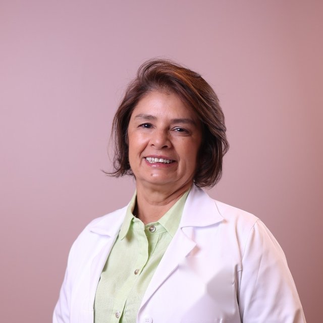 Dra. Mercês Silveira, de jaleco, sorrindo